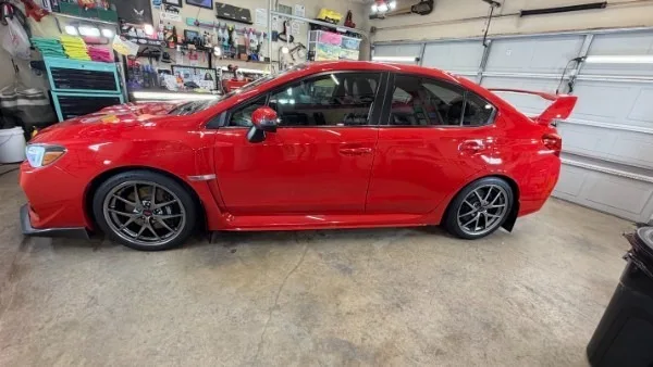 Red Subaru WRX STI side profile after full detail